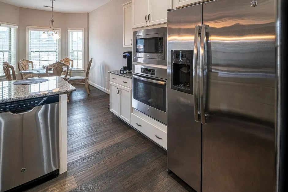 Spacious modern kitchen featuring stainless steel appliances and a dining area.